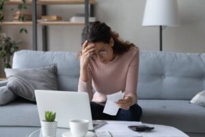 young women looking a bills in despair